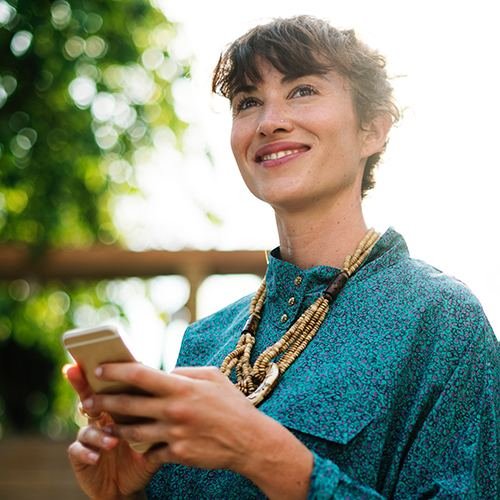 Smiling woman checking social media on her phone